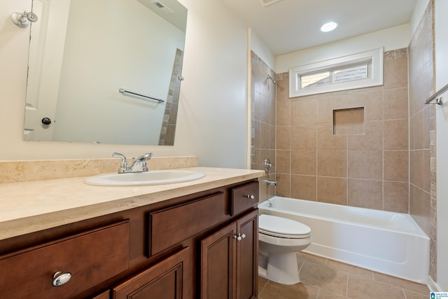 full bathroom featuring tiled shower / bath, vanity, toilet, and tile patterned floors