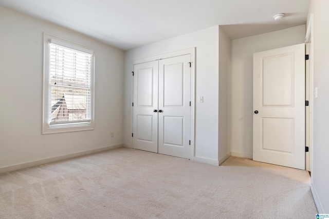 unfurnished bedroom with a closet and light carpet