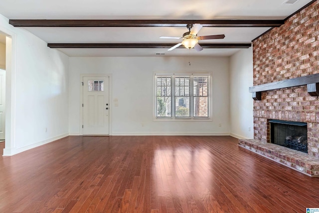 unfurnished living room with beamed ceiling, ceiling fan, a fireplace, and dark wood-type flooring