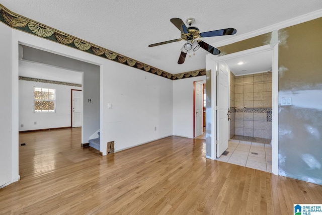 spare room with ceiling fan, a textured ceiling, and light hardwood / wood-style flooring