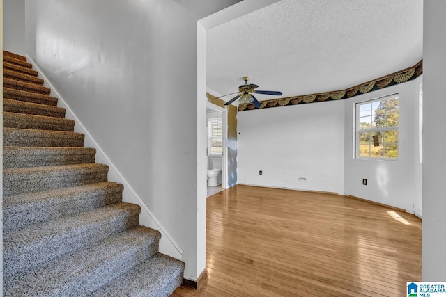 interior space with ceiling fan, hardwood / wood-style floors, and a textured ceiling