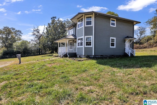 view of side of property featuring a porch and a yard