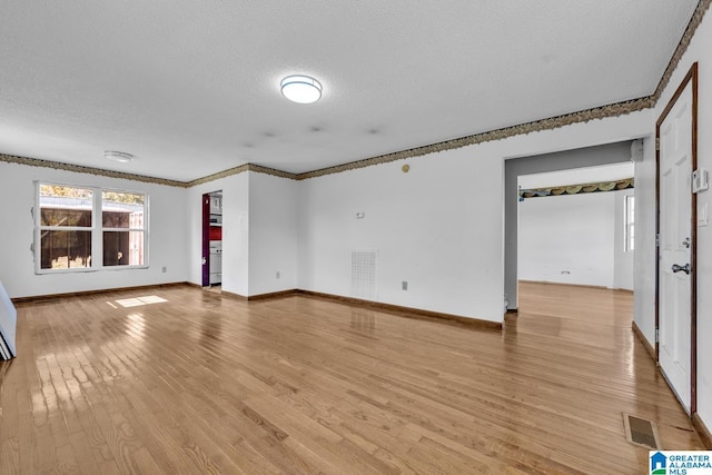 unfurnished living room with light hardwood / wood-style floors and a textured ceiling