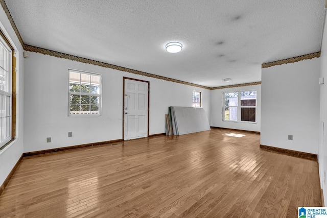 interior space with a textured ceiling and light hardwood / wood-style flooring