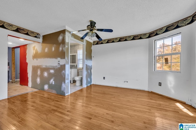 unfurnished room featuring ceiling fan, a textured ceiling, and light wood-type flooring