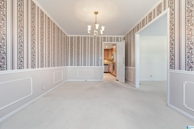 carpeted spare room with crown molding and a chandelier