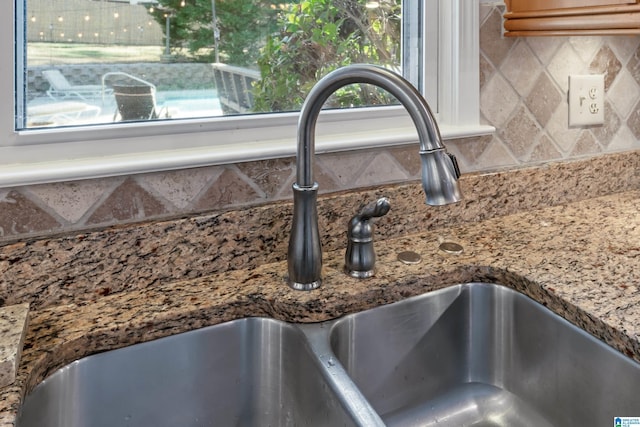 room details featuring tasteful backsplash, stone countertops, and sink