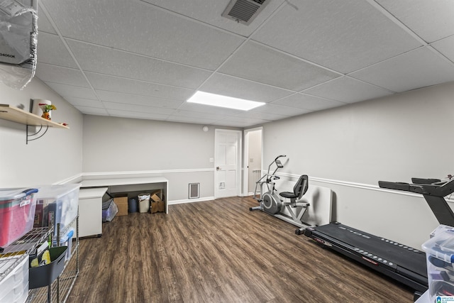 workout area featuring dark wood-type flooring and a drop ceiling