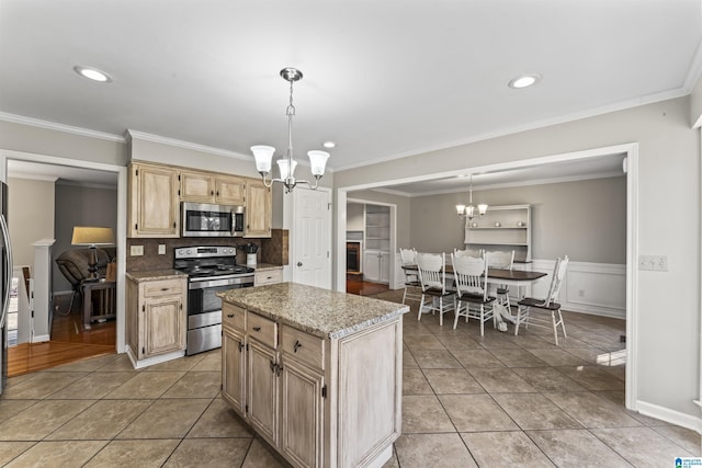 kitchen featuring stainless steel appliances, hanging light fixtures, a center island, and an inviting chandelier