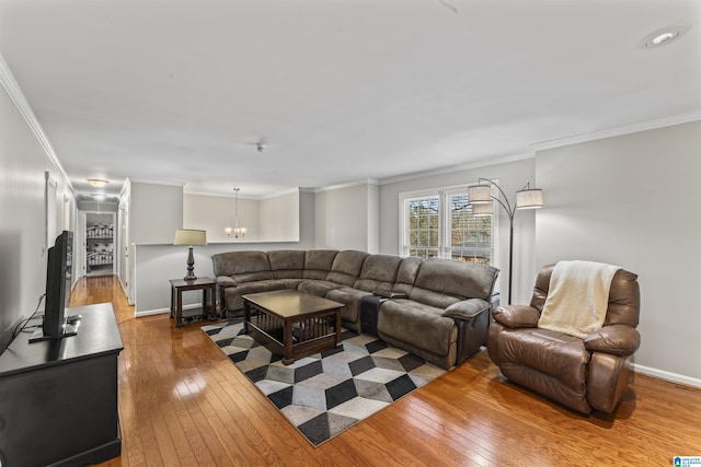 living room with crown molding, hardwood / wood-style flooring, and a chandelier