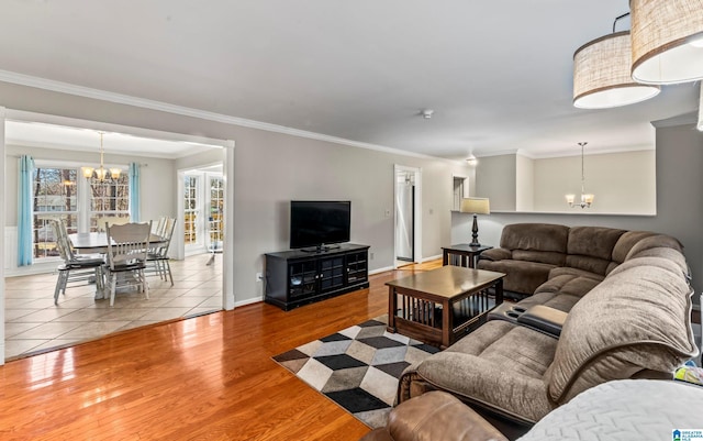 living room featuring ornamental molding, light hardwood / wood-style floors, and a chandelier