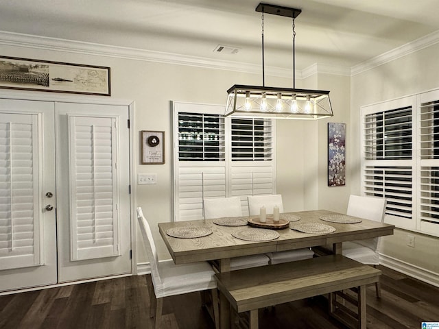 dining area with ornamental molding and dark hardwood / wood-style flooring