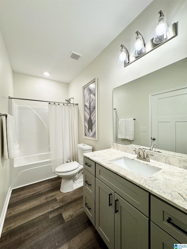 full bathroom featuring hardwood / wood-style flooring, vanity, shower / bath combination with curtain, and toilet