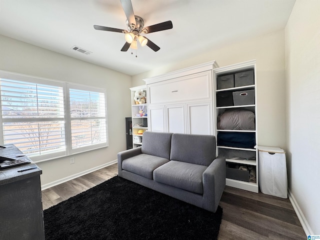 living room featuring ceiling fan and dark hardwood / wood-style floors