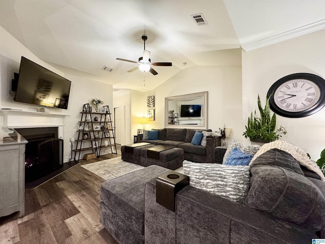 living room with dark wood-type flooring, ceiling fan, lofted ceiling, and crown molding