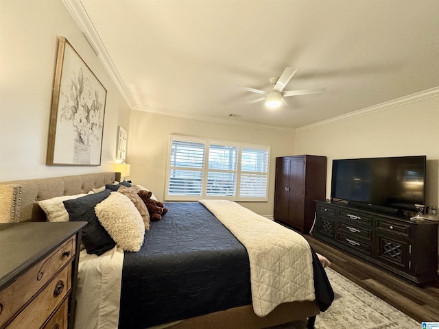 bedroom with dark hardwood / wood-style flooring, ornamental molding, and ceiling fan