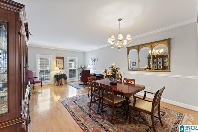 dining room featuring crown molding, a notable chandelier, and light hardwood / wood-style floors