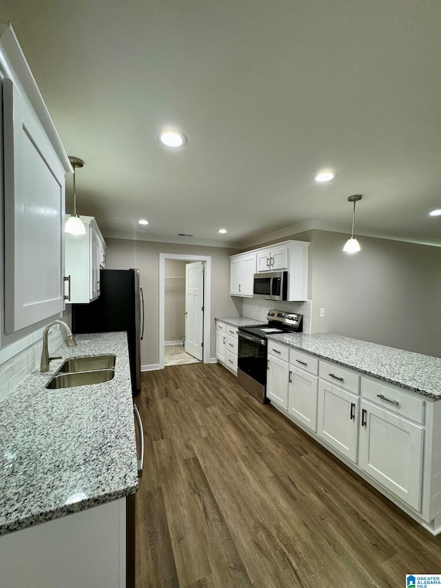 kitchen featuring sink, appliances with stainless steel finishes, hanging light fixtures, light stone counters, and white cabinets