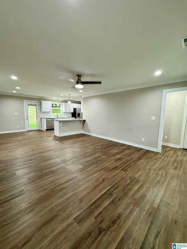 unfurnished living room with ceiling fan and dark hardwood / wood-style flooring