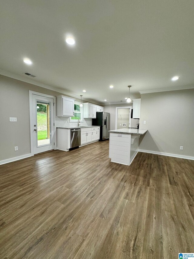 kitchen with white cabinetry, wood-type flooring, hanging light fixtures, kitchen peninsula, and stainless steel appliances