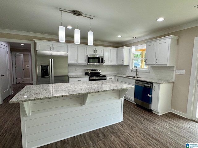 kitchen featuring a kitchen island, appliances with stainless steel finishes, decorative light fixtures, white cabinetry, and sink