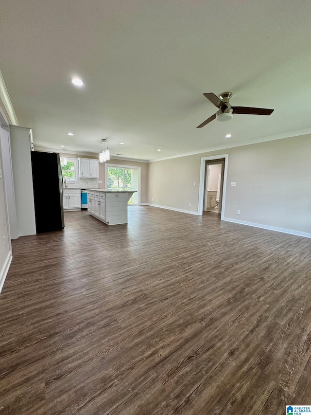 unfurnished living room with dark wood-type flooring, ceiling fan, and crown molding