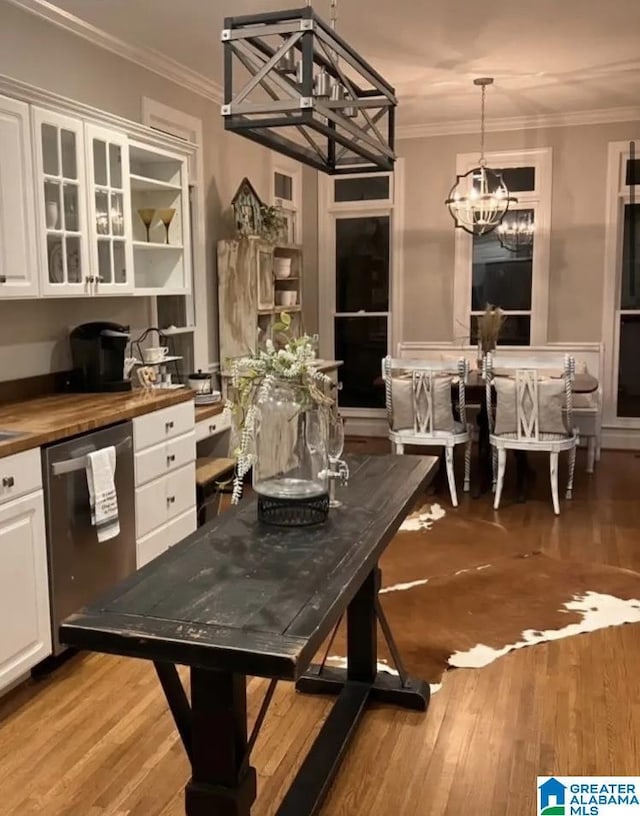 dining room with a notable chandelier, crown molding, and light hardwood / wood-style floors