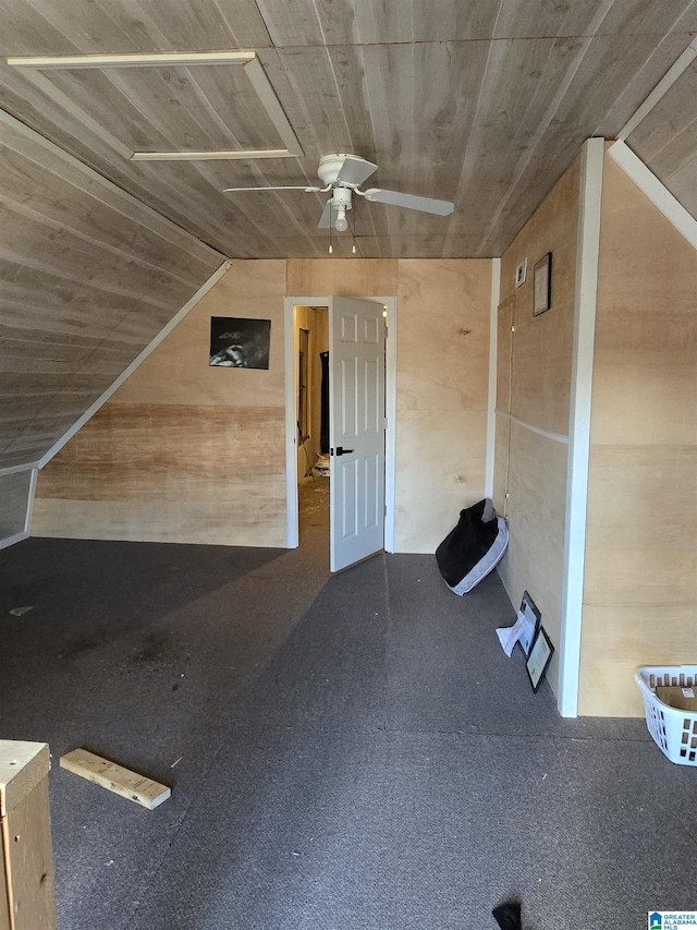 additional living space with wooden walls, wooden ceiling, and ceiling fan