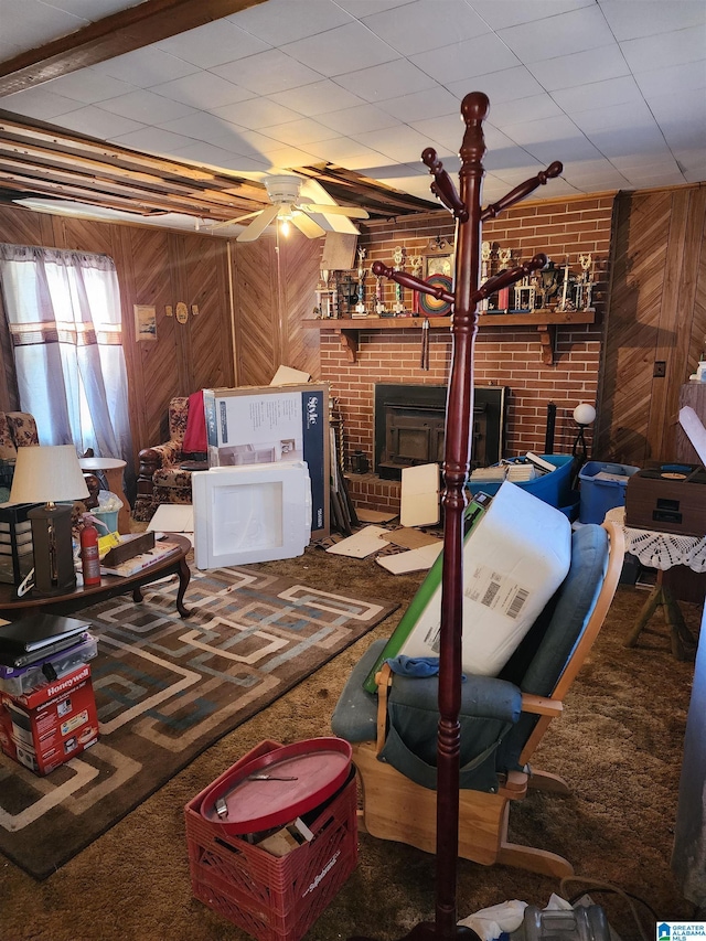 interior space with wooden walls, ceiling fan, and carpet flooring