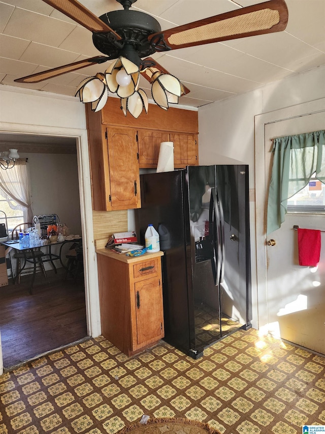 kitchen with ceiling fan, black fridge, a wealth of natural light, and light wood-type flooring