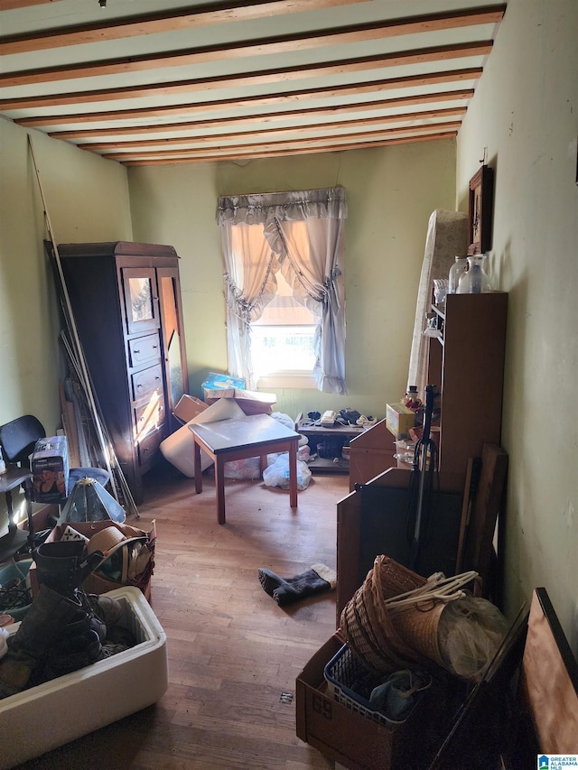 misc room featuring hardwood / wood-style floors and beam ceiling