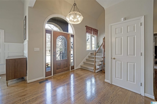 foyer featuring an inviting chandelier, a wealth of natural light, and light hardwood / wood-style floors