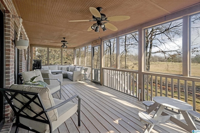 wooden terrace with ceiling fan and an outdoor hangout area