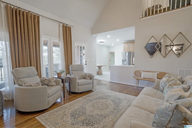 living room with wood-type flooring and high vaulted ceiling