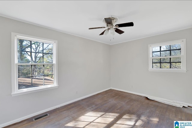 empty room featuring hardwood / wood-style floors, crown molding, a wealth of natural light, and ceiling fan