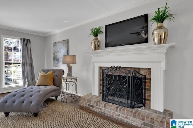 living area with ornamental molding, wood-type flooring, and a brick fireplace