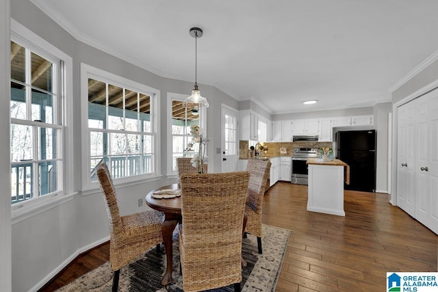 dining space featuring sink, crown molding, and dark hardwood / wood-style floors