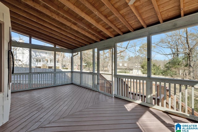 unfurnished sunroom featuring vaulted ceiling with beams and wooden ceiling