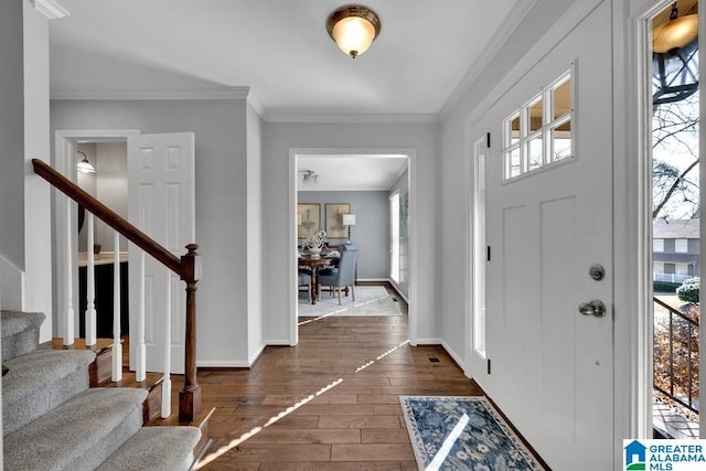 foyer featuring ornamental molding, a wealth of natural light, and dark hardwood / wood-style flooring