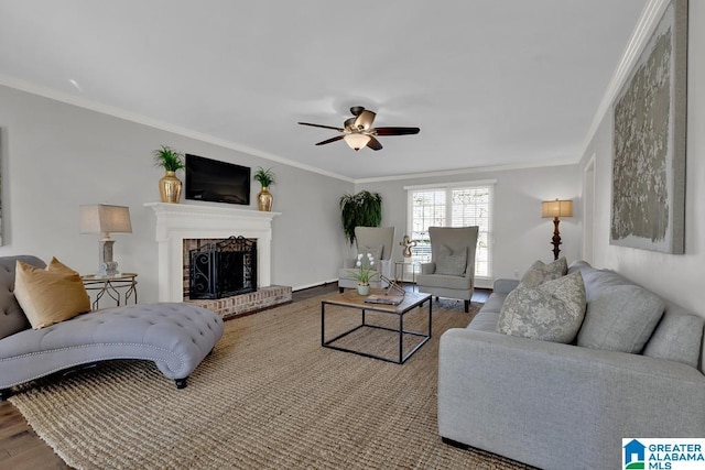 living room with hardwood / wood-style flooring, crown molding, a brick fireplace, and ceiling fan