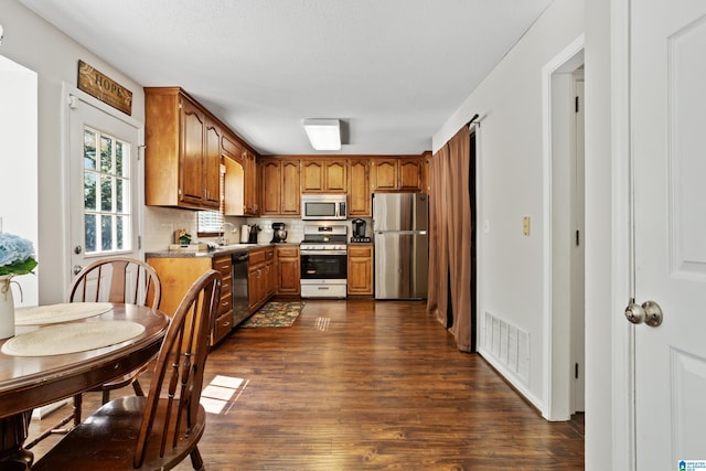 kitchen featuring tasteful backsplash, sink, dark wood-type flooring, and stainless steel appliances