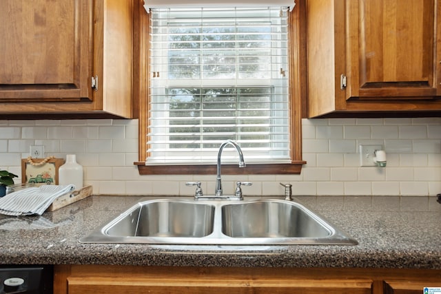 kitchen with dishwashing machine, sink, and backsplash