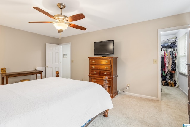 carpeted bedroom featuring ceiling fan, a spacious closet, and a closet