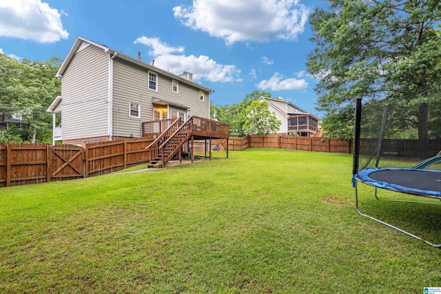 view of yard featuring a trampoline and a wooden deck