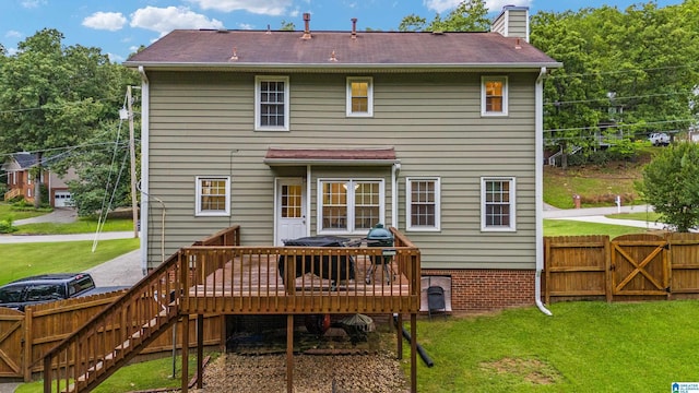 back of house with a wooden deck and a lawn