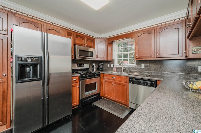 kitchen featuring sink, ornamental molding, appliances with stainless steel finishes, dark tile patterned floors, and decorative backsplash