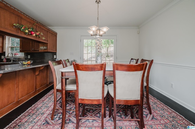 dining area with ornamental molding, a healthy amount of sunlight, and an inviting chandelier