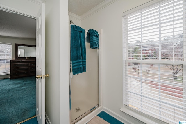 bathroom with crown molding, an enclosed shower, and a textured ceiling