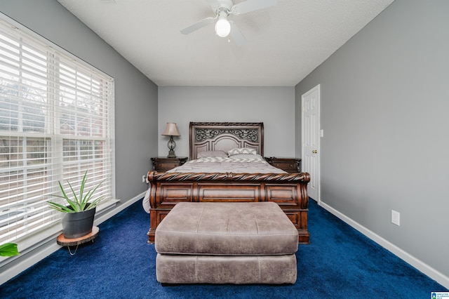 bedroom with dark colored carpet, a textured ceiling, and ceiling fan