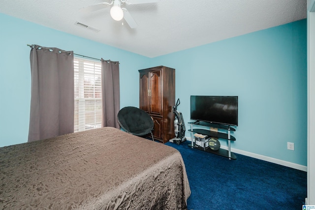 bedroom featuring dark carpet, a textured ceiling, and ceiling fan